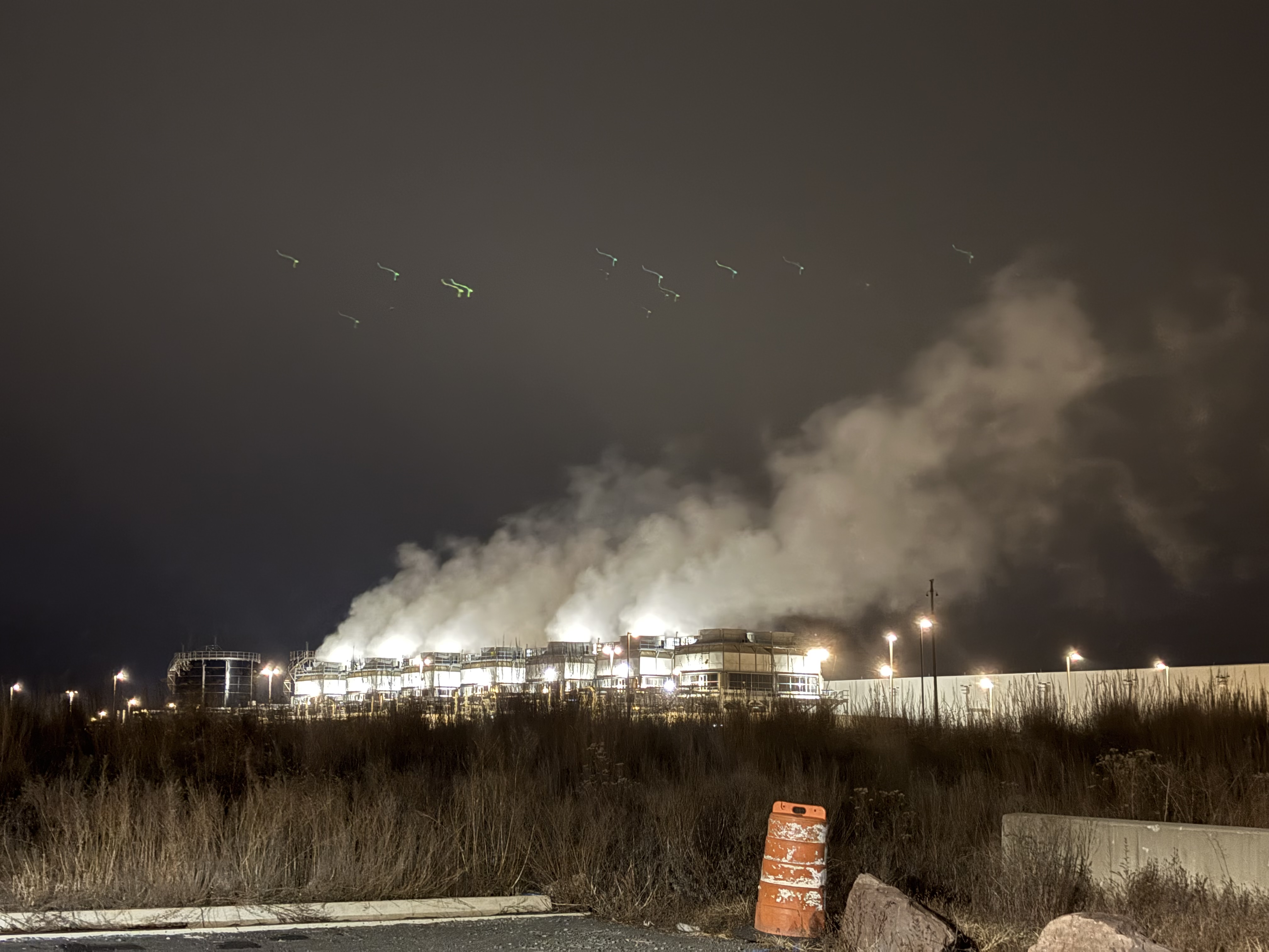 Nighttime view of a hyperscale data center emitting evaporative cooling steam plumes